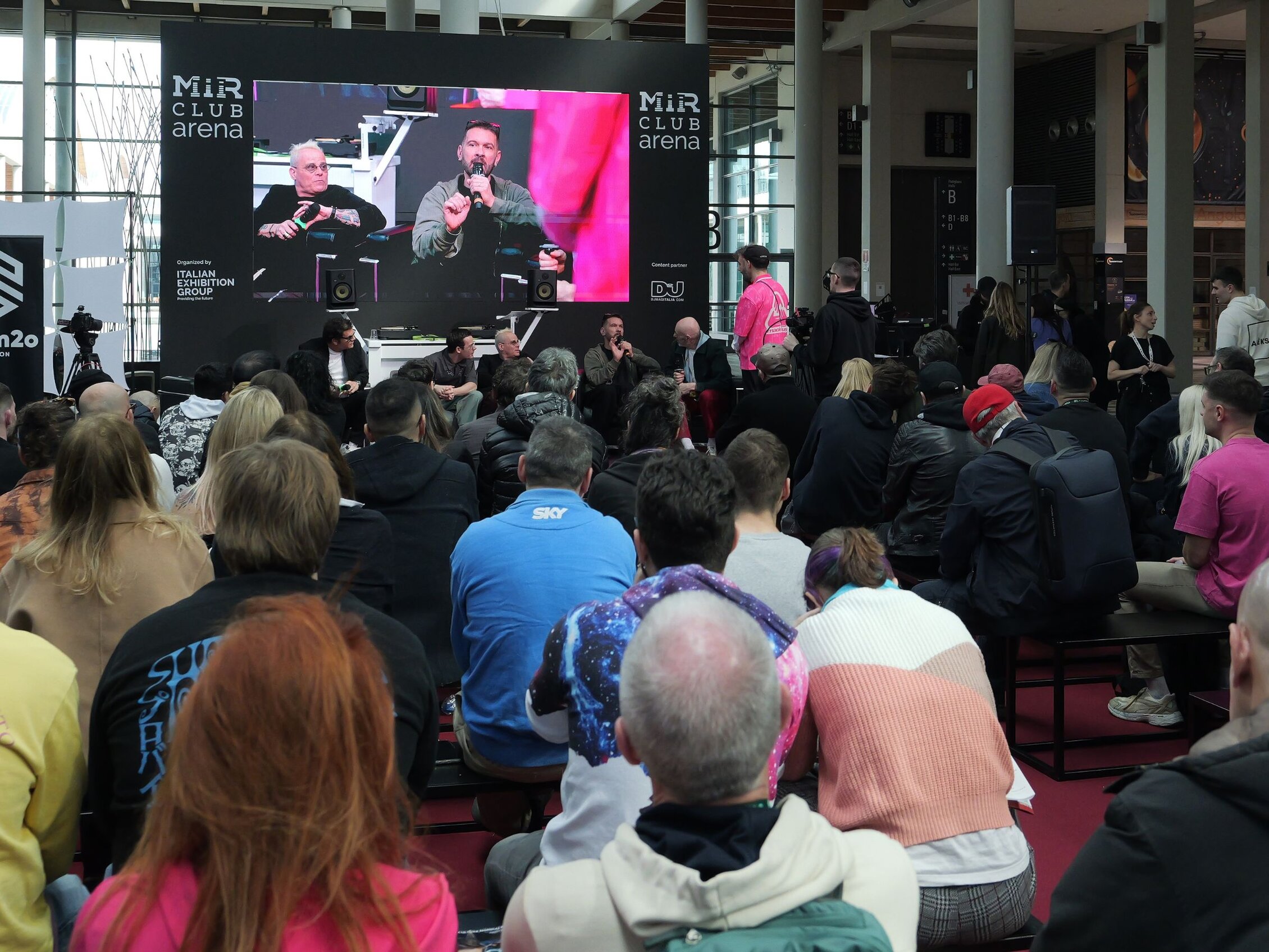 Pubblico assiste a un talk nella MIR Club Arena durante la fiera MIR