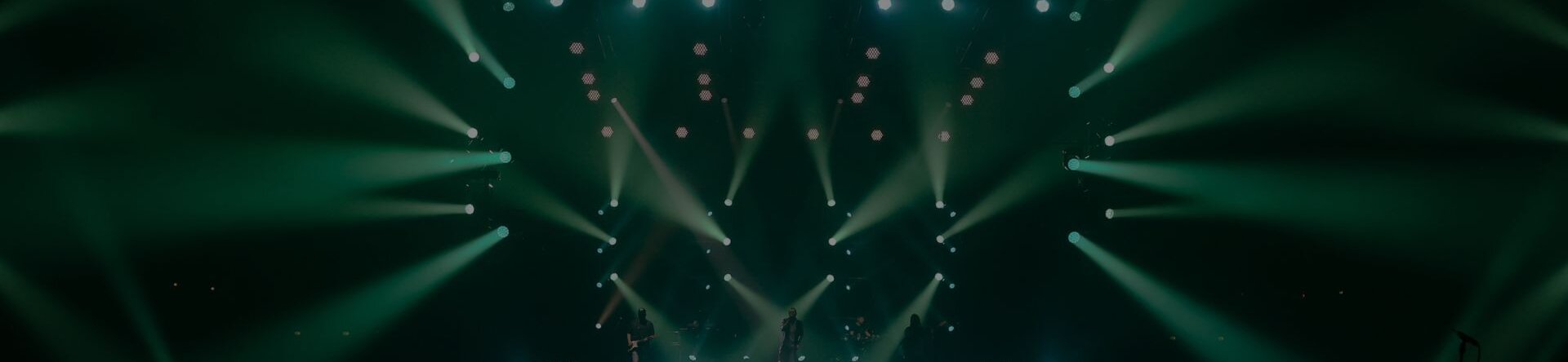 Show di luci su palco Live You Play 2025 con musicisti e pubblico in sala di controllo.