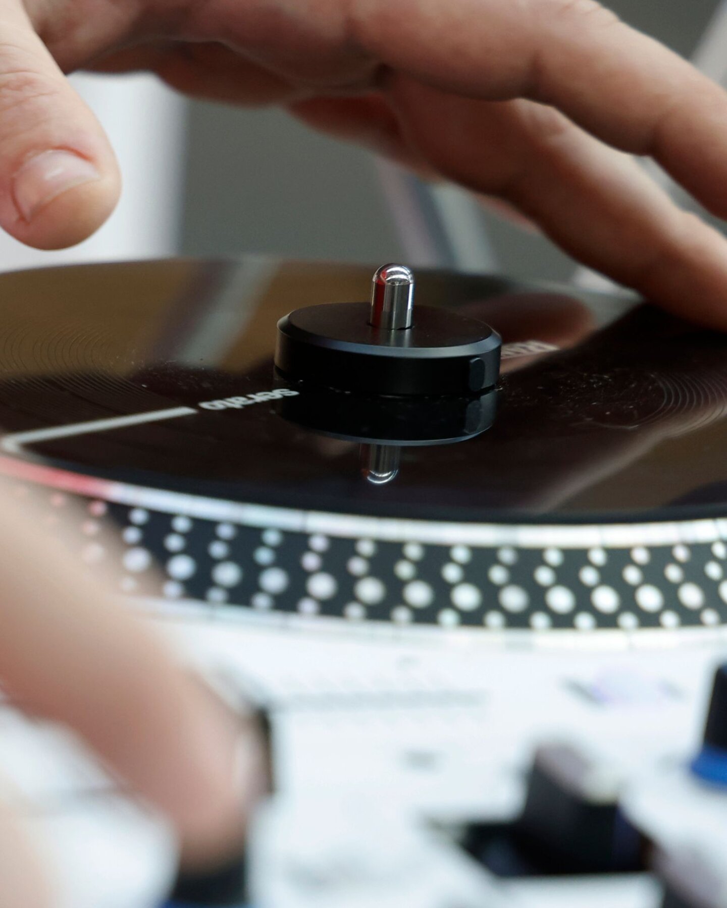 Mano su controller DJ con jog wheel per mixare musica elettronica